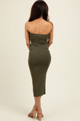 woman wearing an olive green strapless midi dress and beige heeled sandals, view from the back
