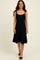 woman wearing a black spaghetti strap fit and flare dress with a ribbed texture