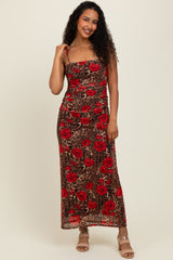 woman wearing a brown leopard print maxi dress with red floral patterns and adjustable spaghetti straps
