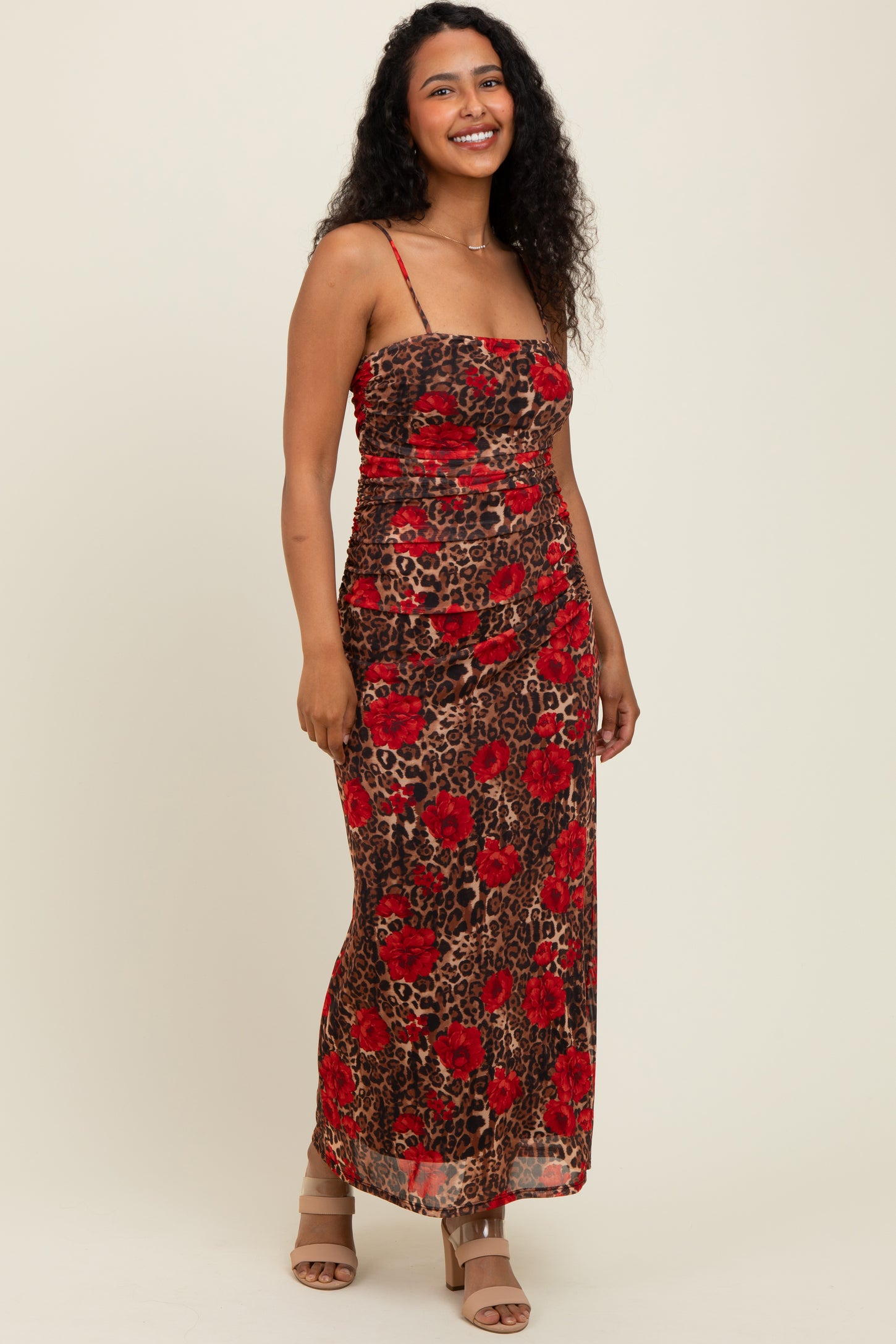 woman wearing a red floral print maxi dress with a fitted bodice and spaghetti straps