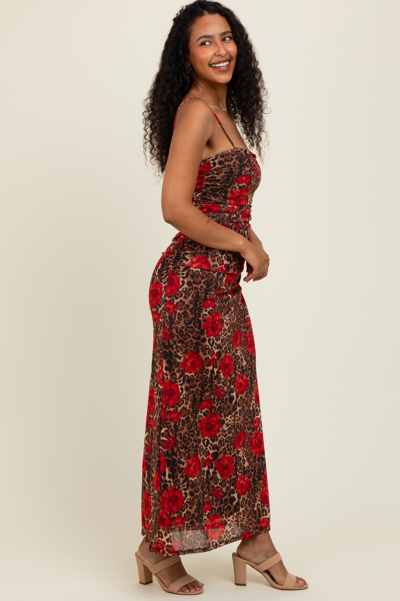 woman wearing a brown and red floral leopard print maxi dress with a fitted bodice and flowing skirt