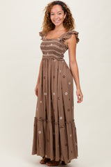 woman wearing a brown floral maxi dress with ruffle sleeves and smocked bodice