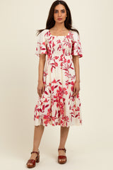woman wearing a white floral midi dress with red flowers and short sleeves, paired with brown block-heeled sandals