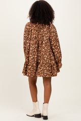 woman wearing a brown floral long sleeve dress with a tiered hem and a flared silhouette, seen from the back