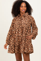 woman wearing a brown floral print long sleeve dress with a tiered skirt and pockets