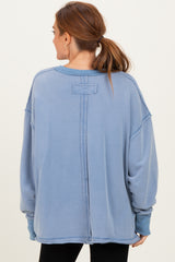 woman wearing a light blue oversized sweatshirt with a split back and dropped shoulders