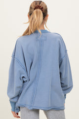 woman wearing a blue oversized maternity sweatshirt with a relaxed fit and crew neckline, viewed from the back