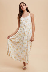 woman wearing a floral maxi dress with adjustable straps and a fitted bodice, posing against a neutral background