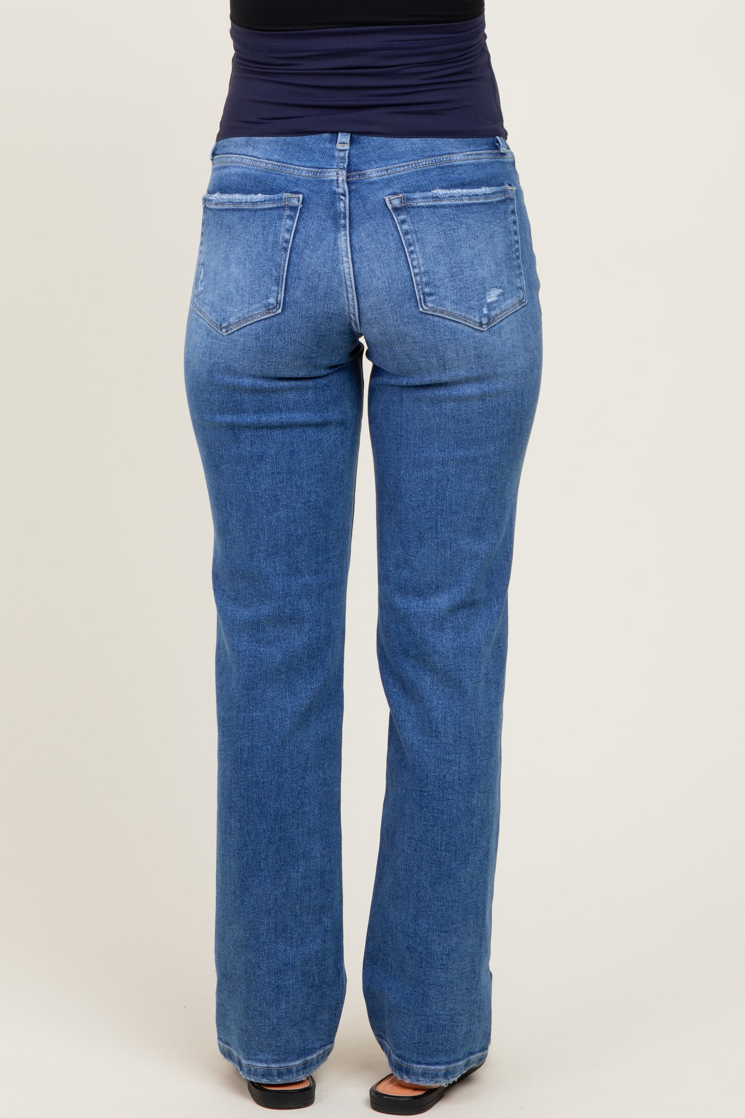 woman wearing maternity light blue straight leg jeans, showing the back view