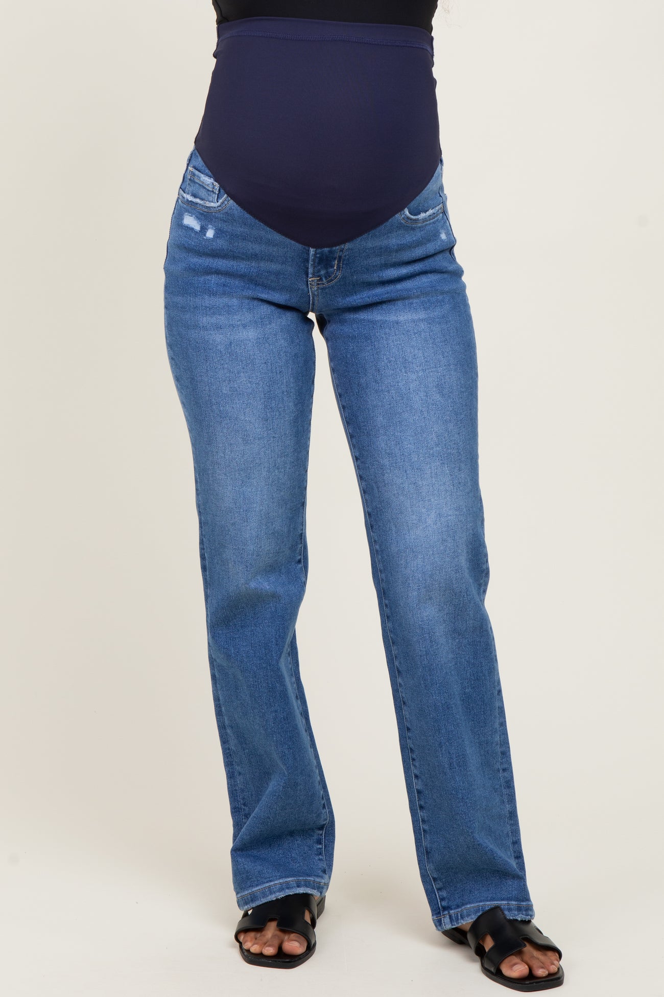 woman wearing dark blue maternity jeans with a stretchy belly panel and a relaxed fit