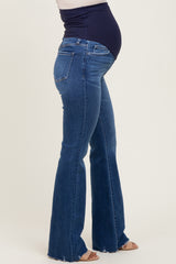 woman wearing dark blue maternity flared jeans, showing a visible baby bump