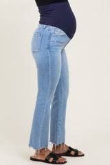 woman wearing light blue distressed maternity jeans with a visible baby bump