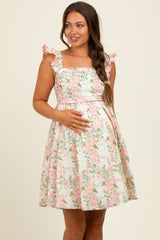 woman wearing a floral print maternity dress with ruffled straps and a visible baby bump