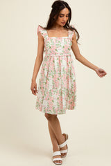 woman wearing a floral print midi dress with cap sleeves and a fitted waist in pink and white