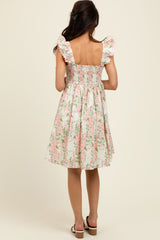 woman wearing a backless floral smocked dress with puff sleeves and a flared skirt