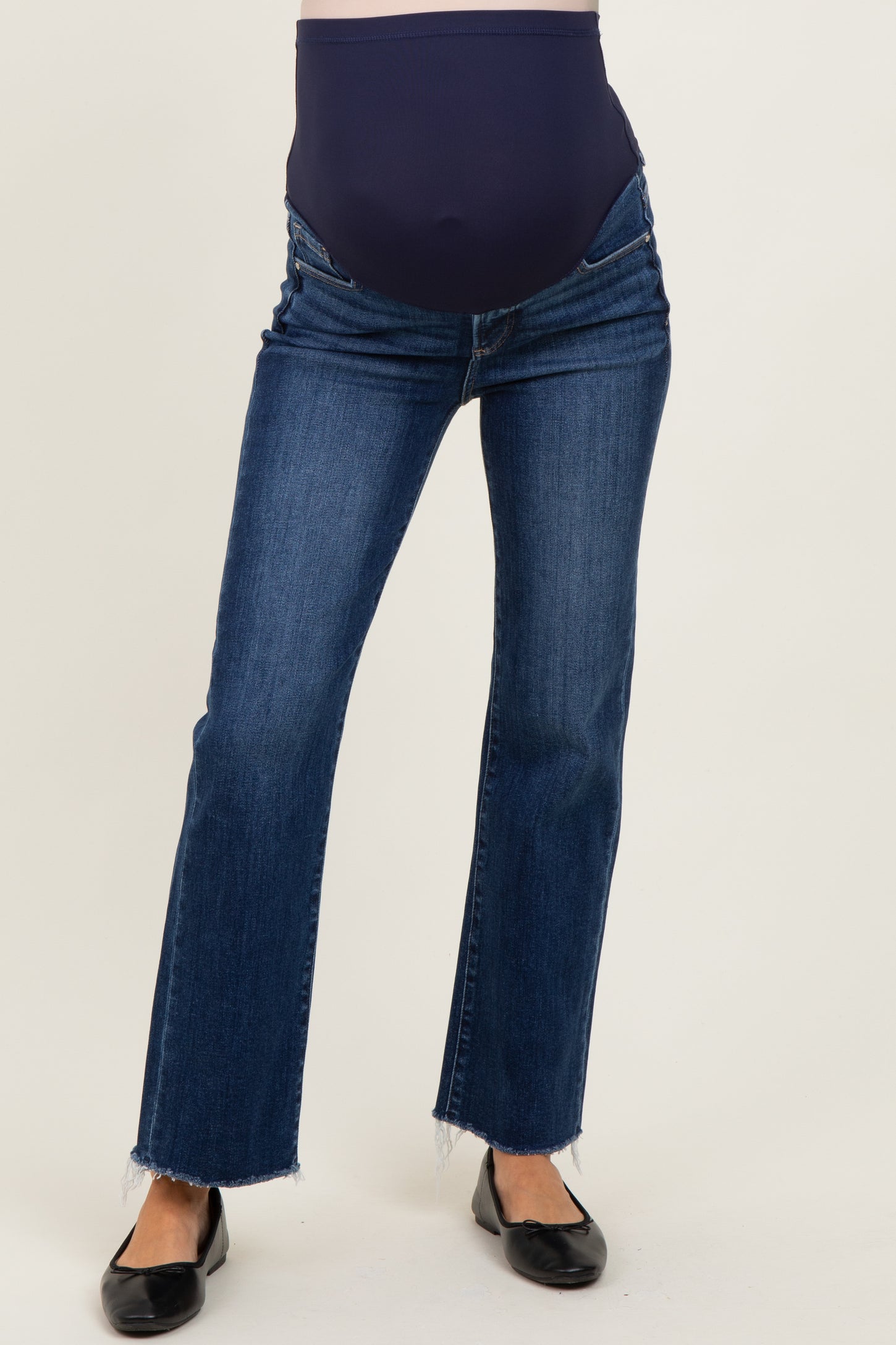 woman wearing dark blue maternity jeans with a supportive waistband and frayed hem