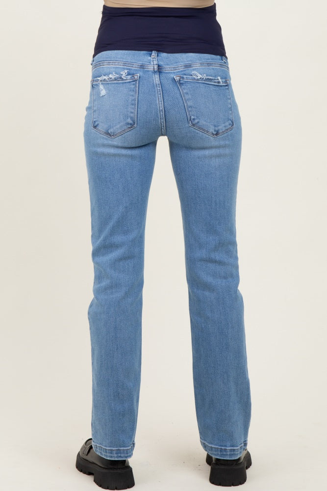 woman wearing light blue maternity jeans, seen from the back, with a relaxed fit and distressed details