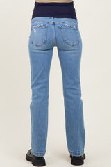 woman wearing light blue maternity jeans, seen from the back, with a relaxed fit and distressed details