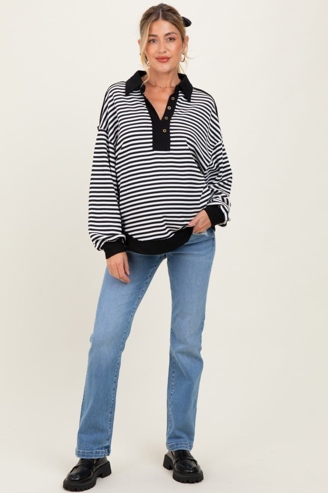 woman wearing a black and white striped maternity sweatshirt with a collar and buttons, styled with light blue jeans