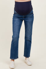 woman wearing dark blue maternity jeans with a supportive belly panel and white sneakers