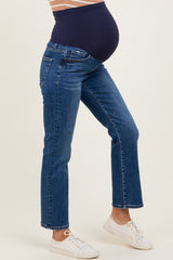 woman wearing blue maternity jeans with a supportive belly band and a visible baby bump
