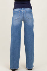 woman wearing light blue maternity jeans with a wide-leg fit and a stretchy black waistband, showing the back view