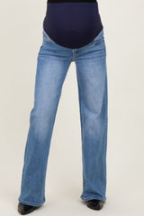woman wearing light blue maternity jeans with a dark blue waistband and a relaxed fit