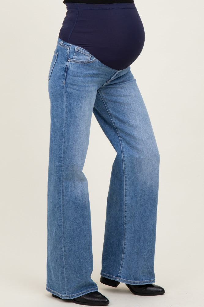woman wearing blue maternity jeans with a wide leg and a supportive over-the-bump waistband, showing a visible baby bump