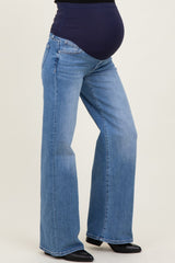 woman wearing blue maternity jeans with a wide leg and a supportive over-the-bump waistband, showing a visible baby bump