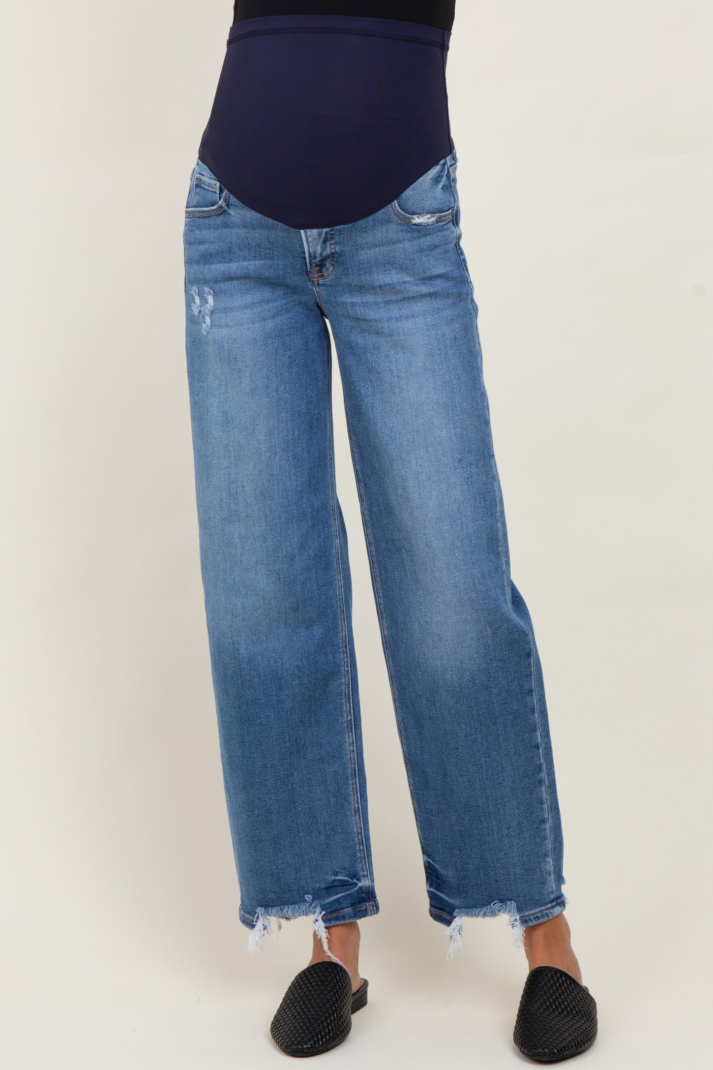 woman wearing blue maternity wide-leg jeans with a dark blue over-the-bump waistband and frayed hem