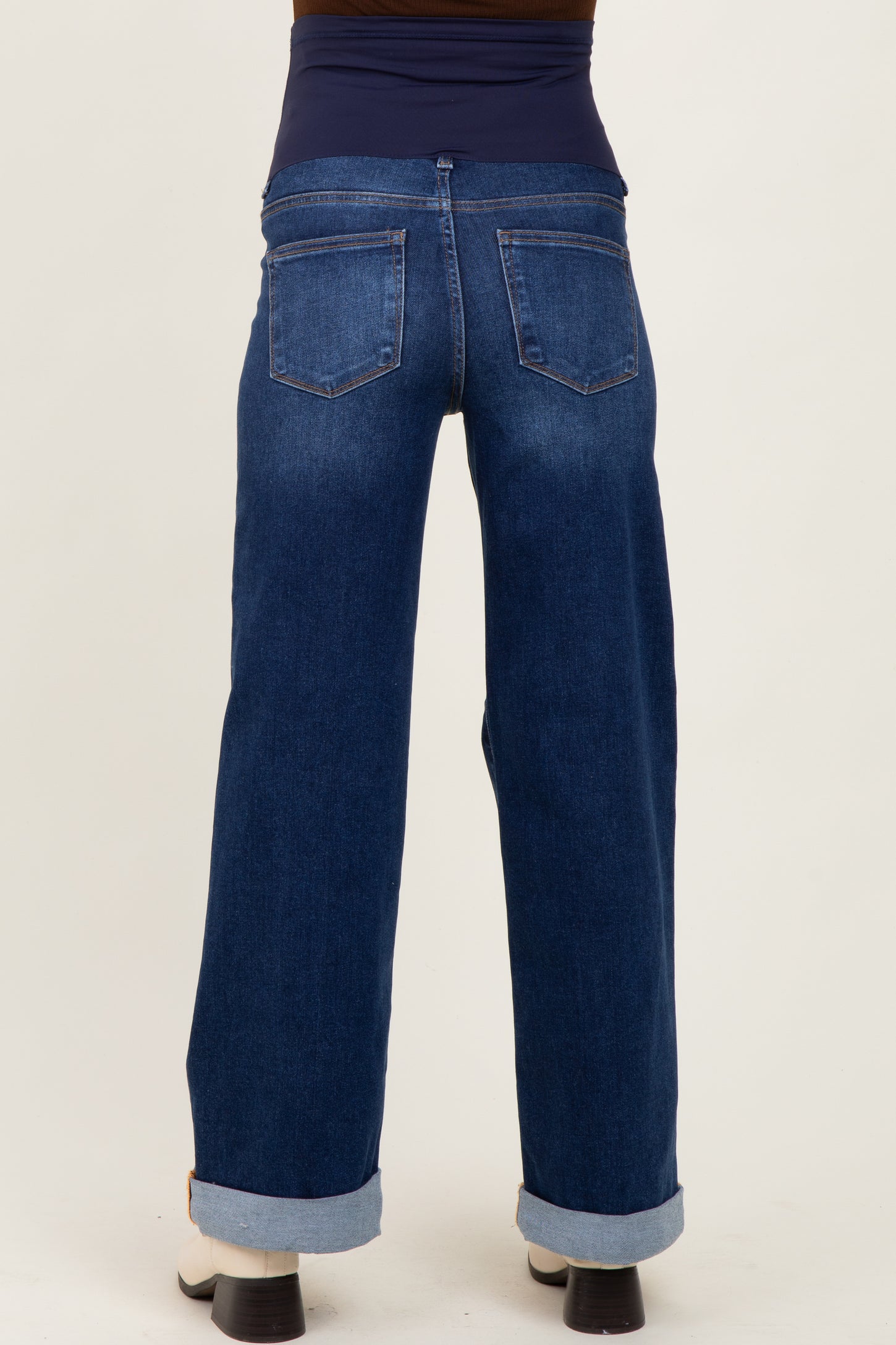 woman wearing dark blue maternity wide-leg jeans with a stretchy waistband and rolled cuffs from the back