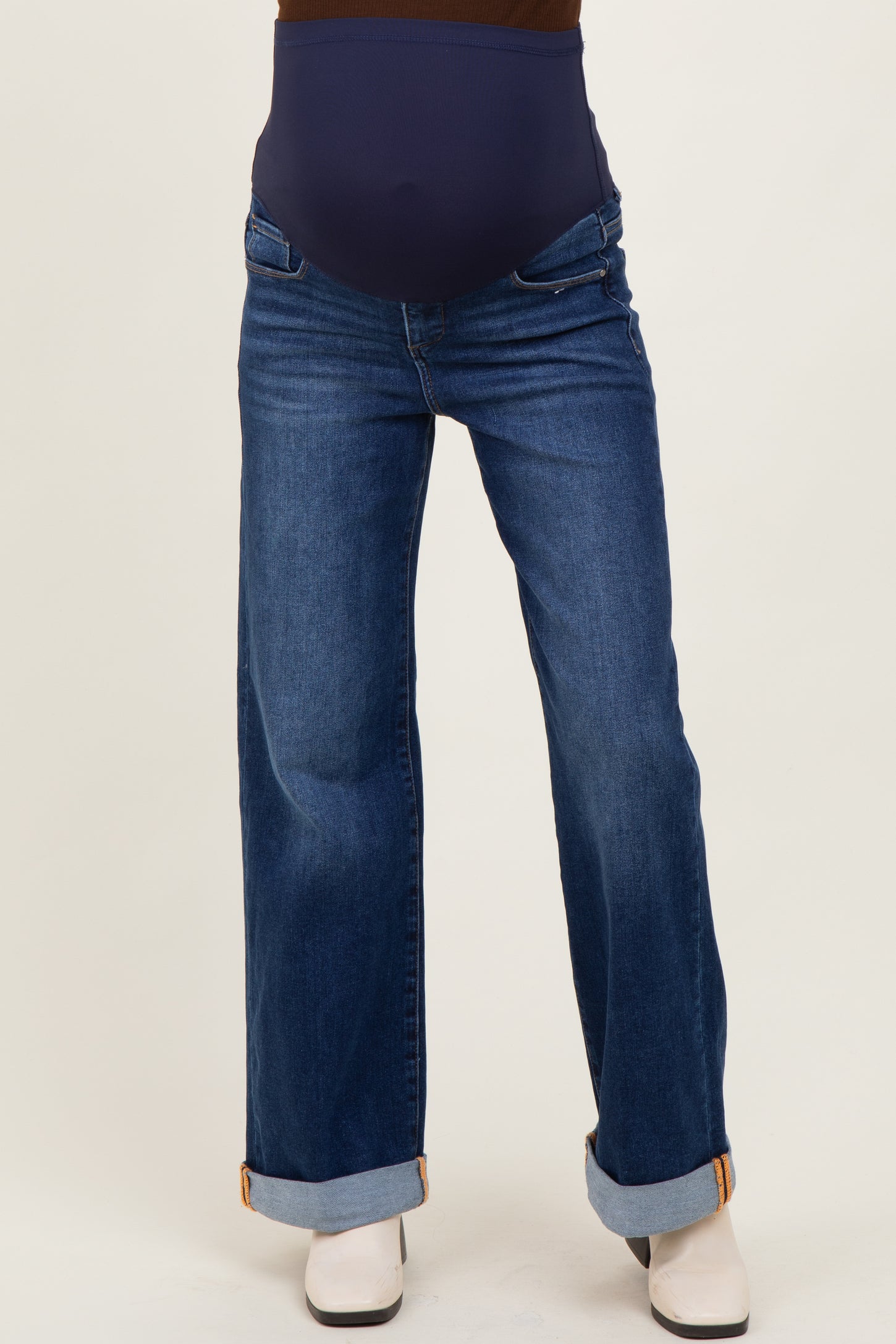 woman wearing a pair of dark wash maternity jeans with a wide leg and a stretchy bump support waistband