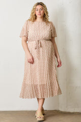 woman wearing a light pink floral plus-size midi dress with short sleeves and a tie waist detail