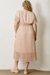 woman wearing a pink floral print plus-size midi dress with short sleeves and a pleated skirt viewed from the back
