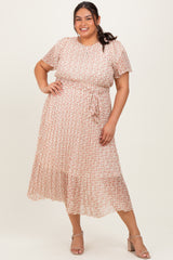 woman wearing a pink and white patterned plus size midi dress with short sleeves and a tie waist detail