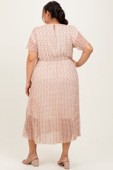 woman wearing a light pink plus size maxi dress with a floral pattern and short sleeves, seen from the back