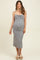 woman wearing a black and white patterned maternity dress with ruffled details and spaghetti straps, visible baby bump
