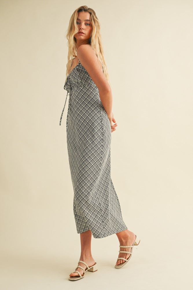 woman wearing a black and white checkered maxi dress with a fitted bodice and adjustable straps