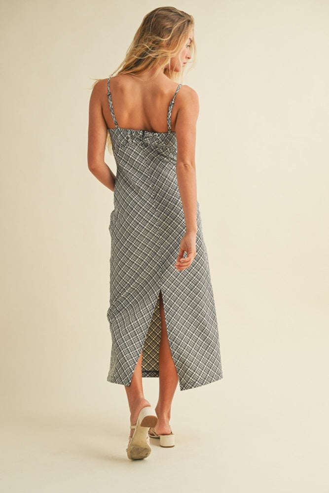 woman wearing a black and white patterned maxi dress with a back slit and spaghetti straps