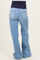 maternity wear light wash denim flared jeans with a supportive navy waistband shown from the back
