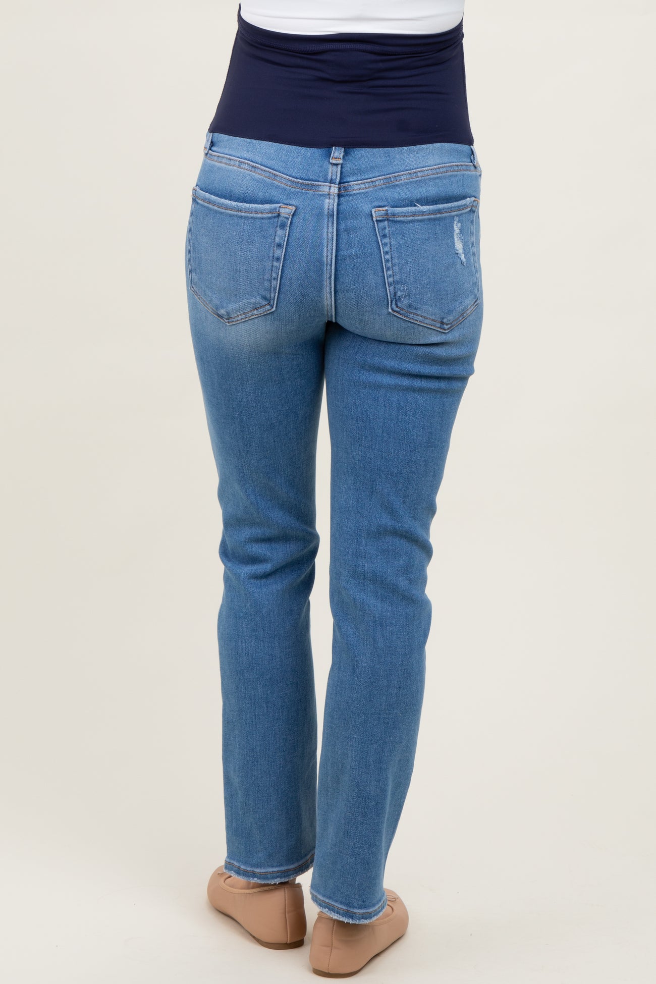 woman wearing light blue maternity jeans with a navy belly panel, shown from the back