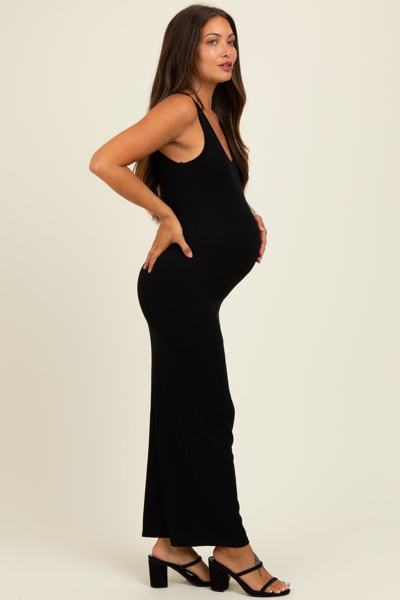 woman wearing a black ribbed maternity maxi dress with a visible baby bump