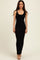 woman wearing a fitted black ribbed maxi dress with a scoop neckline and side slit