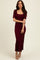woman wearing a burgundy ribbed maxi dress with short sleeves and a side slit, styled with beige heels