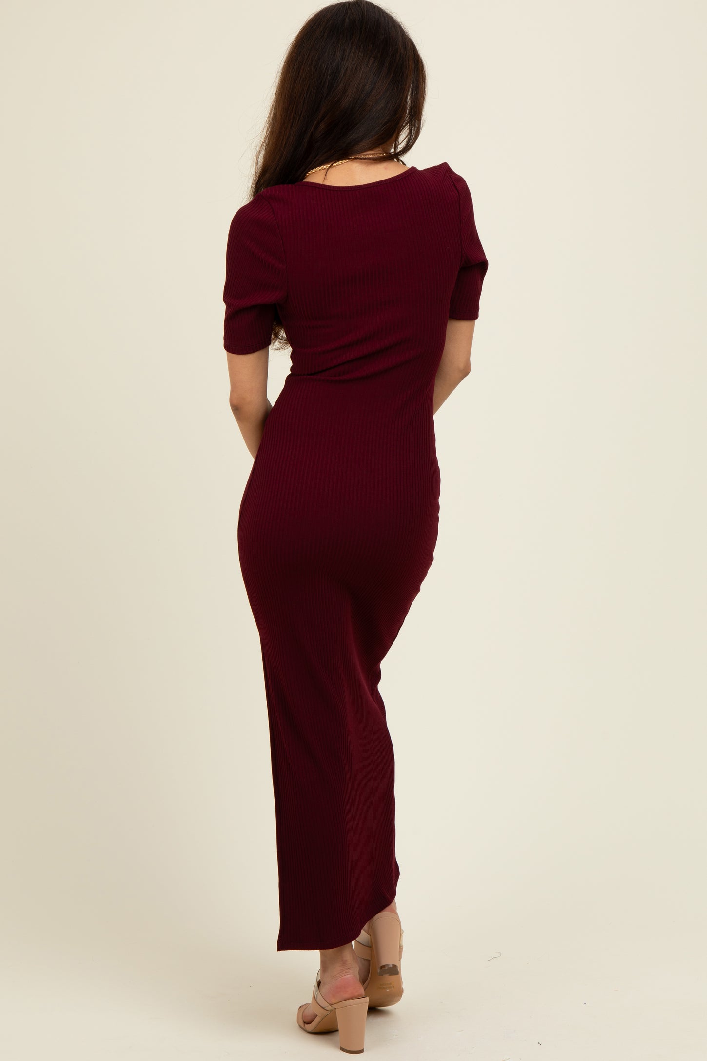 woman wearing a burgundy ribbed maxi dress with short sleeves, viewed from the back