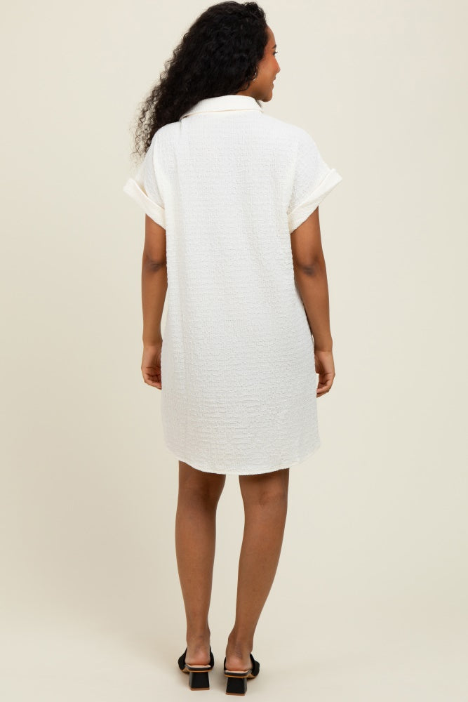 woman wearing a white short-sleeve dress with a collar and rolled sleeves, view from the back