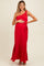 woman wearing a red one-shoulder maternity dress with a side tie and holding her baby bump