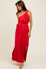 woman wearing a red one-shoulder maxi dress with a tie waist and side slits