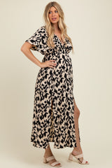 woman wearing a leopard print maternity maxi dress with short sleeves and a side slit, showing her baby bump
