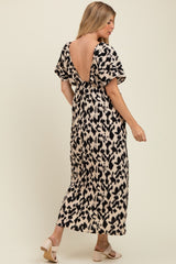 woman wearing a leopard print backless maternity maxi dress, showing off her baby bump
